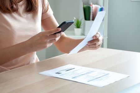 Business owner taking a photo of an expense receipt with their phone